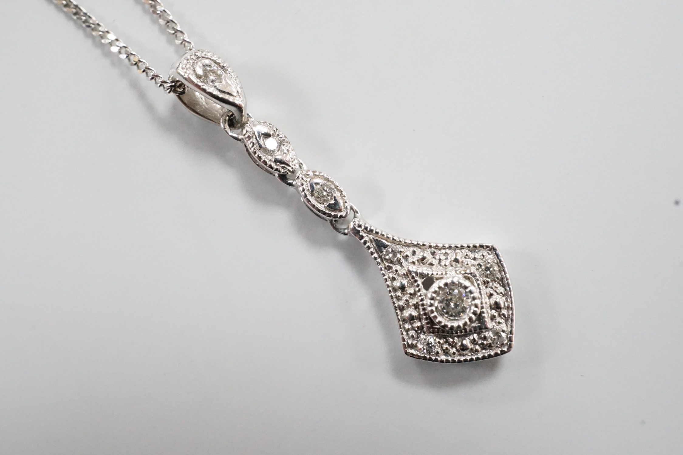 A modern 375 white metal and diamond chip set drop pendant, 23mm, gross 0.6 grams on an 18ct white gold chain, 46cm and one other 18ct white gold chain, 40cm, 18ct gross 2.9 grams.